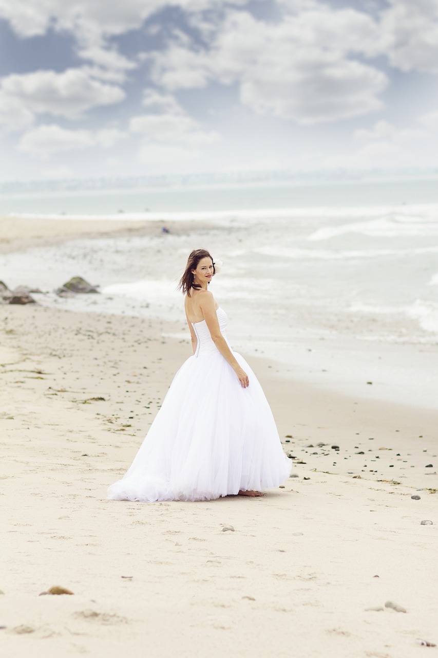 femme en robe de mariée qui marche sur la plage